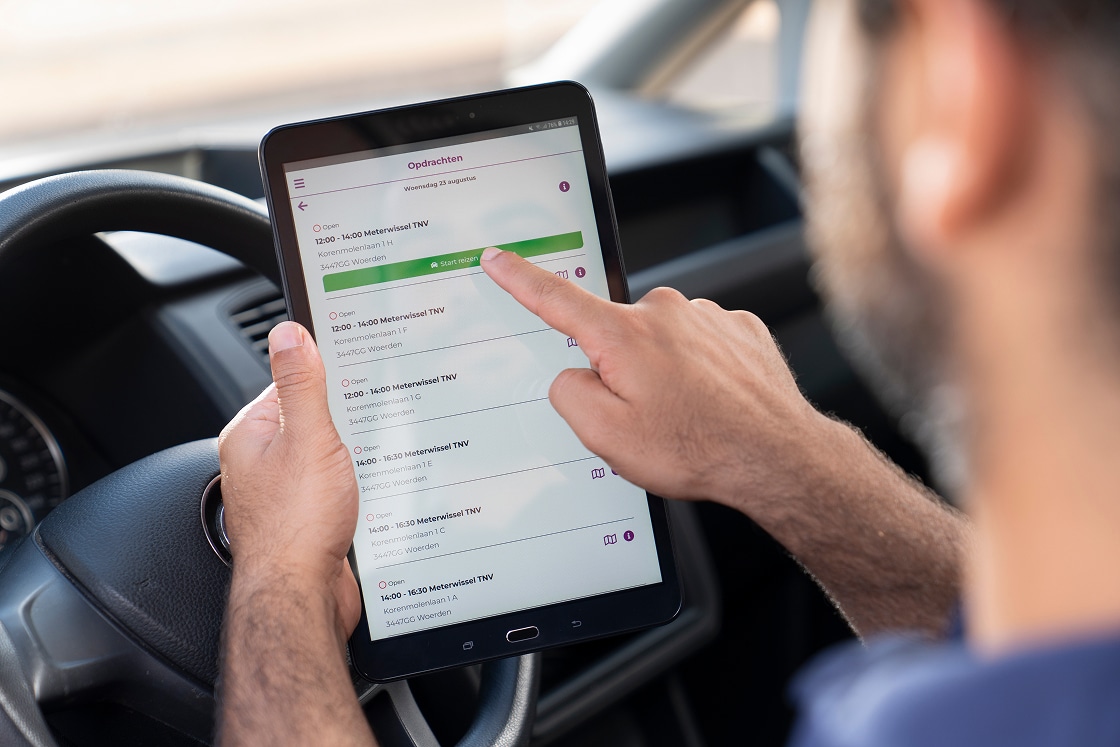monteur in auto met ipad die opdracht start