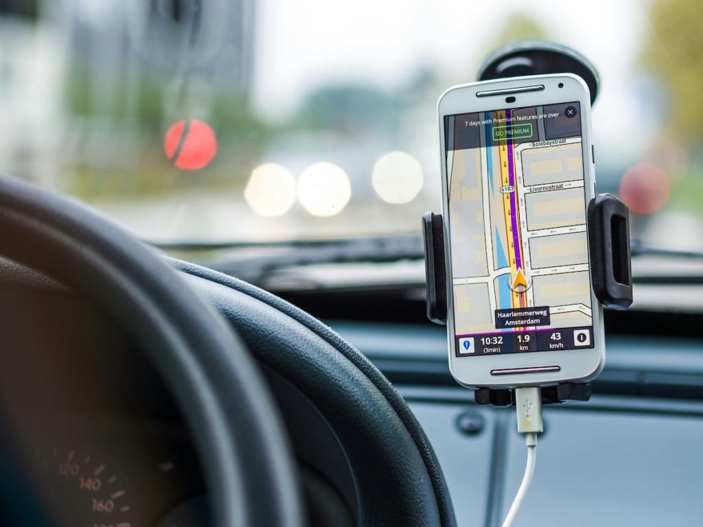 auto met mobiel met routeplanner aan